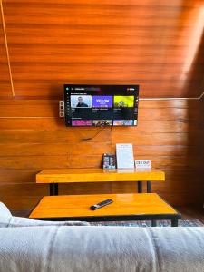 ein Wohnzimmer mit einem TV an einer Holzwand in der Unterkunft Godieng Cabin in Diyeng