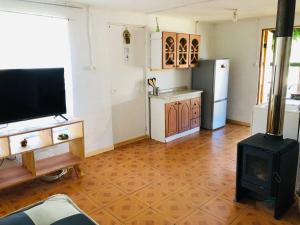 a living room with a stove and a refrigerator at Linda Casa en Carretera Austral in La Junta