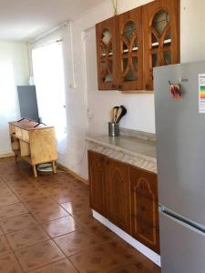 a kitchen with a refrigerator and a table in it at Linda Casa en Carretera Austral in La Junta
