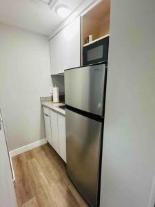 a kitchen with a stainless steel refrigerator and white cabinets at Coral Gables Miami Studio near Airport and Beaches in Miami