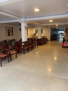 um restaurante com mesas e cadeiras de madeira numa sala em Du Hung 2 Hotel em Hà Tiên
