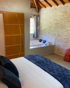 um quarto com uma cama e uma banheira em Villagio da Mantiqueira em Monte Verde