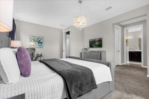 een slaapkamer met een groot wit bed met paarse kussens bij 4 Bedrooms - 3,5 Bathrooms - Solara 9032 Em in Kissimmee