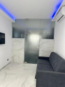 a living room with a couch and a glass shower at La Dimora di Dominique in Bari