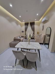 ein Wohnzimmer mit einem Tisch, Stühlen und einem Sofa in der Unterkunft أجنحة فندقية مفروشة عوائل فقط in Bisha