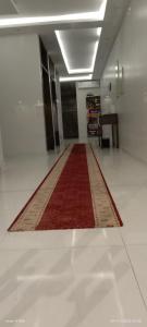 un pasillo con una alfombra roja en el suelo en أجنحة فندقية مفروشة عوائل فقط, en Qal'at Bishah