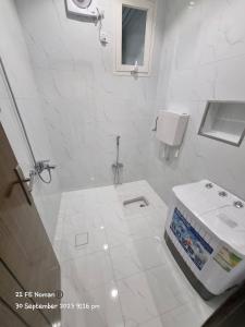 ein weißes Bad mit einem WC und einem Waschbecken in der Unterkunft أجنحة فندقية مفروشة عوائل فقط in Bisha