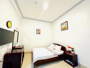 a bedroom with a bed and a flat screen tv at Du Hung 2 Hotel in Hà Tiên