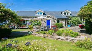 een huis met een tuin met een paraplu bij Tir a Mor in Nefyn