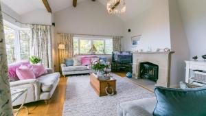 een woonkamer met open haard en tv bij Tir a Mor in Nefyn