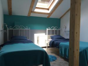 クルジュ・ナポカにあるRetro Hostelの緑の壁と天窓が備わる客室で、ベッド2台が備わります。