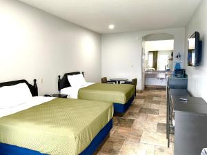 a hotel room with two beds and a kitchen at Texas Inn La Feria in La Feria