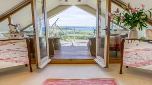 een kamer met een deur naar een balkon bij Tir a Mor in Nefyn