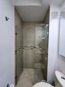 a bathroom with a glass shower with a toilet at Apartamento Vacacional Girardot Aqualina Green in Girardot