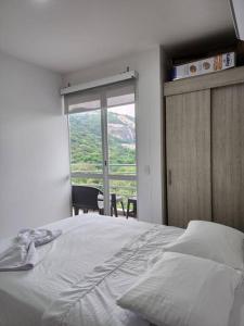 a bedroom with a bed and a large window at Apartamento Vacacional Girardot Aqualina Green in Girardot