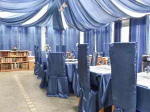 a room with tables and chairs with blue drapes at Shiralee in Middle Winterslow