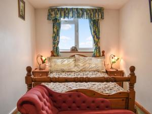 a bedroom with a wooden bed and a window at Shiralee in Middle Winterslow