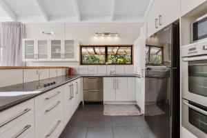 a kitchen with white cabinets and a window at River Retreat, spa, pets, Wi-Fi in Turangi
