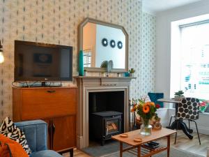George Apartment 54 في Whithorn: غرفة معيشة مع موقد ومرآة