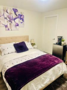 a bedroom with a purple blanket on a bed at Premium Suite in London