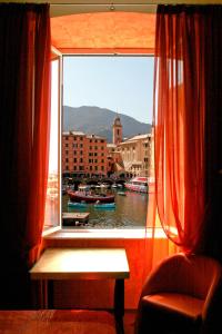 a window with a view of a harbor with boats at I Tre Merli Locanda in Camogli
