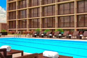 a hotel with a swimming pool in front of a building at The Westin Oaks Houston at the Galleria in Houston