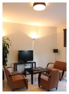 salon z telewizorem, 2 krzesłami i stołem w obiekcie Hotel El Trebol w mieście Carboneras