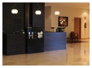 a waiting room with a counter and two pendant lights at Hotel El Trebol in Carboneras