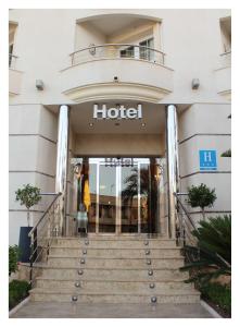 a hotel entrance with stairs in front of it at Hotel El Trebol in Carboneras