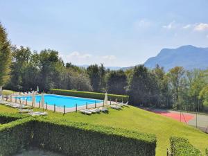 a large swimming pool with lounge chairs in a yard at Belvilla by OYO BOS03 3 in Grantola