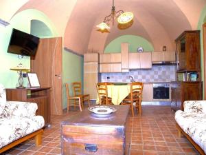 a kitchen and living room with a couch and a table at Belvilla by OYO La Foresteria di San Leo in Trivigno
