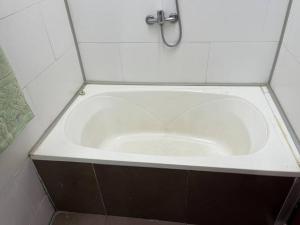a white bath tub in a white tiled bathroom at Casa cabaña in Paysandú