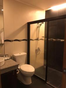 y baño con aseo y ducha acristalada. en Subic Grand Seas Resort en Olongapo