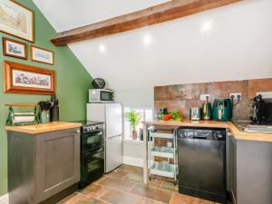 a kitchen with green walls and stainless steel appliances at The Stables - Uk44766 in Ripon