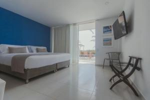 1 dormitorio con 1 cama y TV en la pared en Hotel San Luis Beach House, en San Andrés