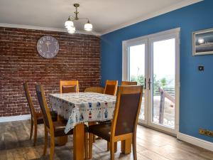 斯特蘭拉爾的住宿－Fyebrae，一间设有桌椅和砖墙的用餐室