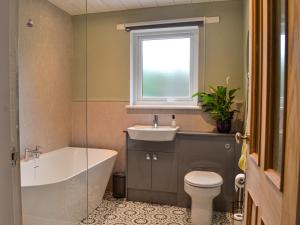 斯特蘭拉爾的住宿－Fyebrae，带浴缸、盥洗盆和卫生间的浴室