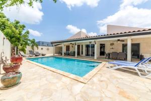 een villa met een zwembad en een huis bij Casa Luna in Palm-Eagle Beach