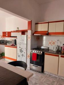una cocina con estufa y refrigerador en MAILY Guest House, en Alta Gracia