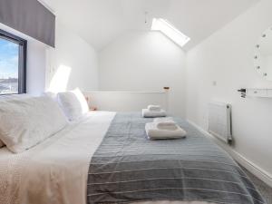 a white bedroom with a large bed with two towels on it at Molly Veroni - Uk43592 in Ellesmere