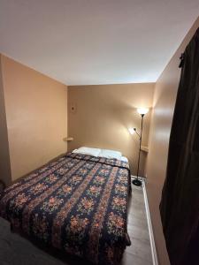 1 dormitorio con 1 cama con una manta colorida en Relax Inn en Streator