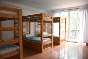 3 Etagenbetten in einem Zimmer mit Fenster in der Unterkunft Zoila's Suite Escape in Nuevo Tingo