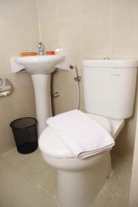 een badkamer met een wit toilet en een wastafel bij Hersya Front One Inn Surabaya in Surabaya