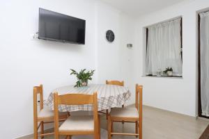 stół jadalny z krzesłami i telewizor na ścianie w obiekcie Apartments with a parking space Vantacici, Krk - 18476 w mieście Malinska