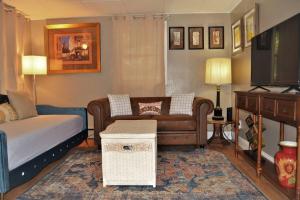 uma sala de estar com um sofá, uma cama e uma televisão em The Red 6 em Grand Forks