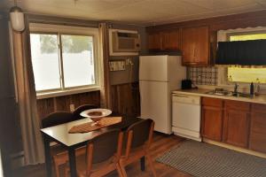 uma pequena cozinha com uma mesa e um frigorífico branco em The Red 6 em Grand Forks