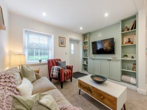 a living room with a couch and a tv at Rose Cottage in Llanfair-Dyffryn-Clwyd