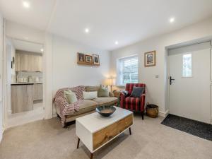 a living room with a couch and a table at Rose Cottage in Llanfair-Dyffryn-Clwyd