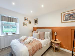 a bedroom with a bed with towels on it at Rose Cottage in Llanfair-Dyffryn-Clwyd