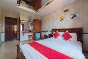 een slaapkamer met een groot bed met rode kussens bij Hotel Nhu Y 2 in Ho Chi Minh-stad
